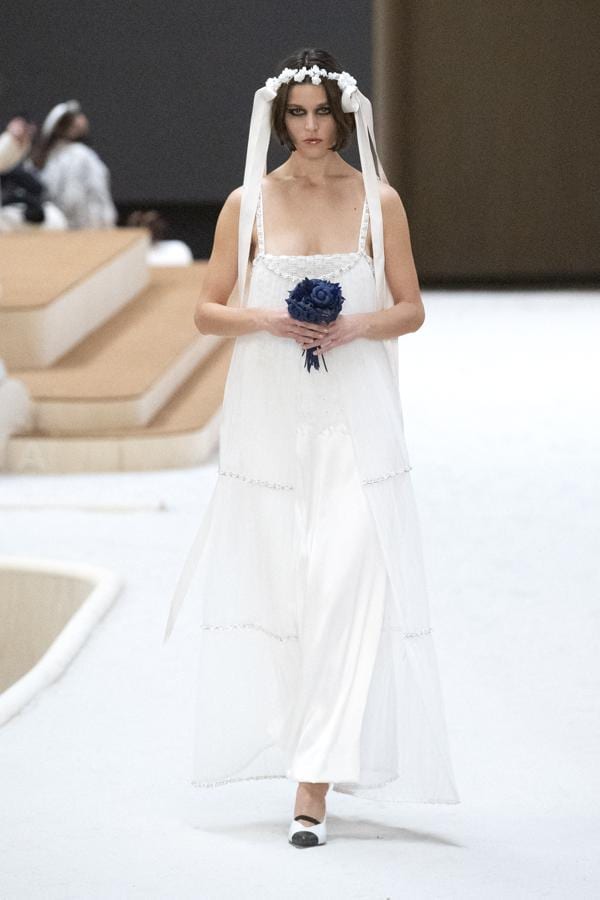 Chanel: tocado de flores. El tocado de flores complementando a vestidos de inspiración retro, como el que propone Chanel en su desfile de Alta Costura primavera/ verano 2022.