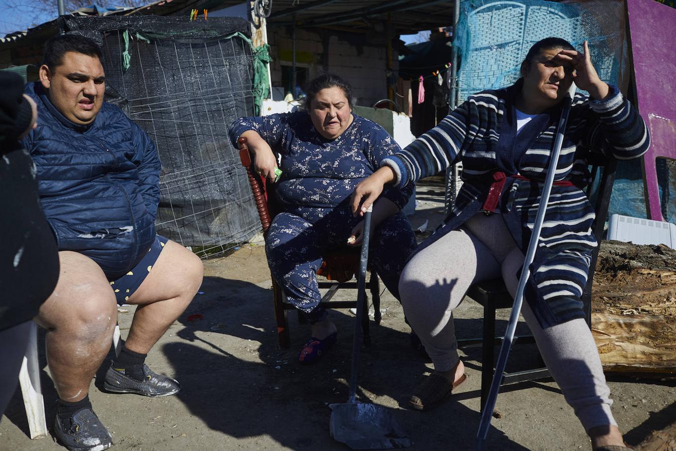 Miembros de una de las familias del asentamiento disfrutan al mediodía del clima primaveral. 