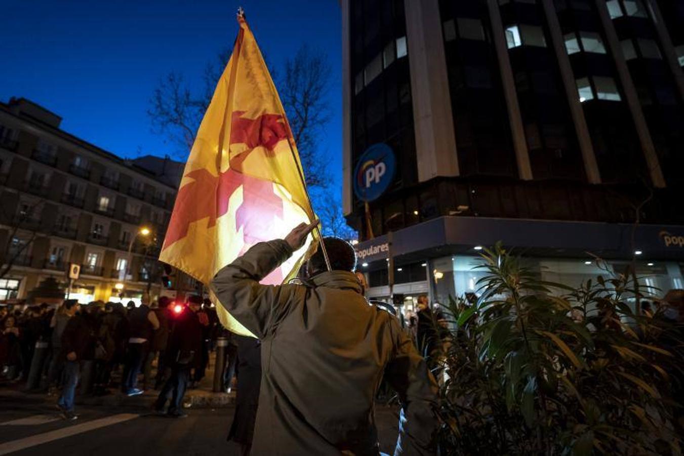 Un manifestante con una bandera con la Cruz de Borgoña. 