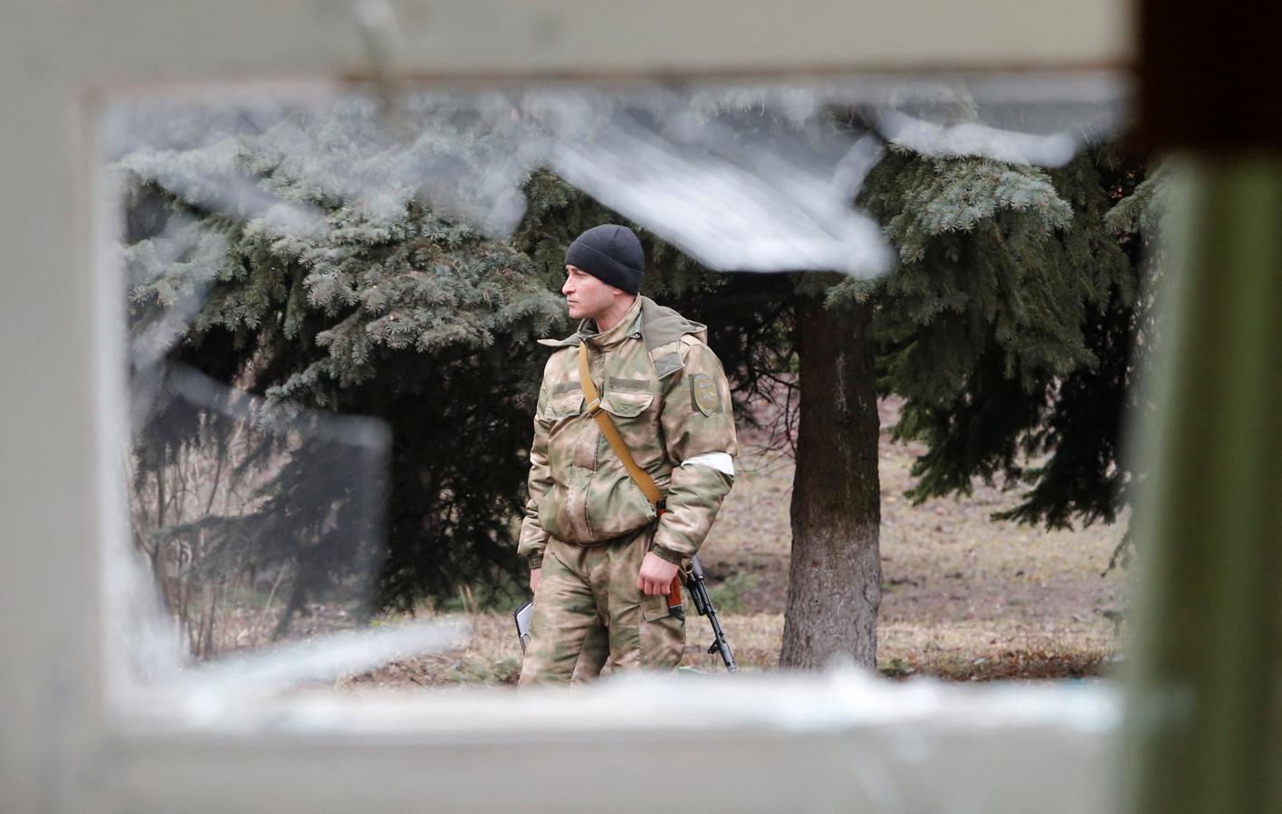 Un soldado observa un colegio dañado en Donetsk. 