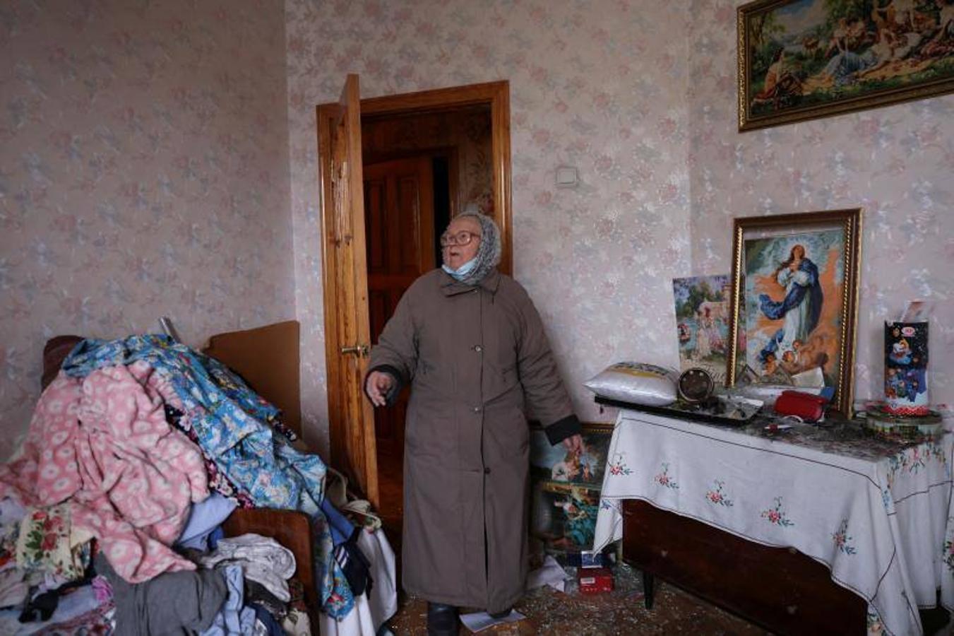 Una mujer entra en una habitación de su casa tras un ataque. 