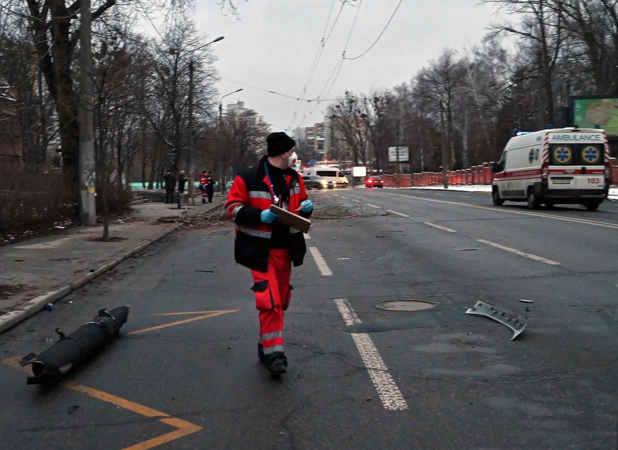 Un médico camina junto al fragmento de un misil tras el ataque a la torre de televisión de Kiev. 