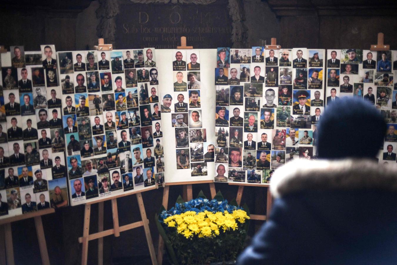 Una persona reza ante un altar con las fotografías de todos los soldados muertos en la guerra del Donbás en 2014. 