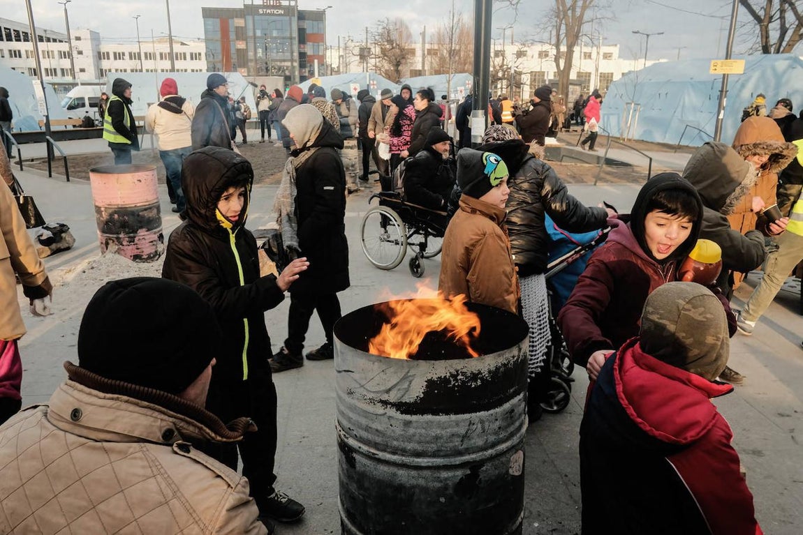 Niños y familias se agolpan en una estación de Leópolis para coger un tren con destino Polonia. 