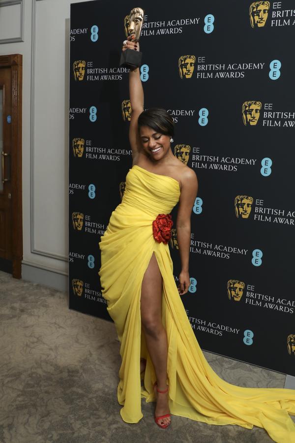 Ariana DeBose - Premios Bafta 2022. Muy colorida con un vestido amarillo limón de Oscar de la Renta con un drapeado, escote palabra de honor y abertura lateral que terminaba en una cola lateral. Como accesorios, unas sandalias rojas a juego con la rosa de la cadera y joyería de Bvlgari.