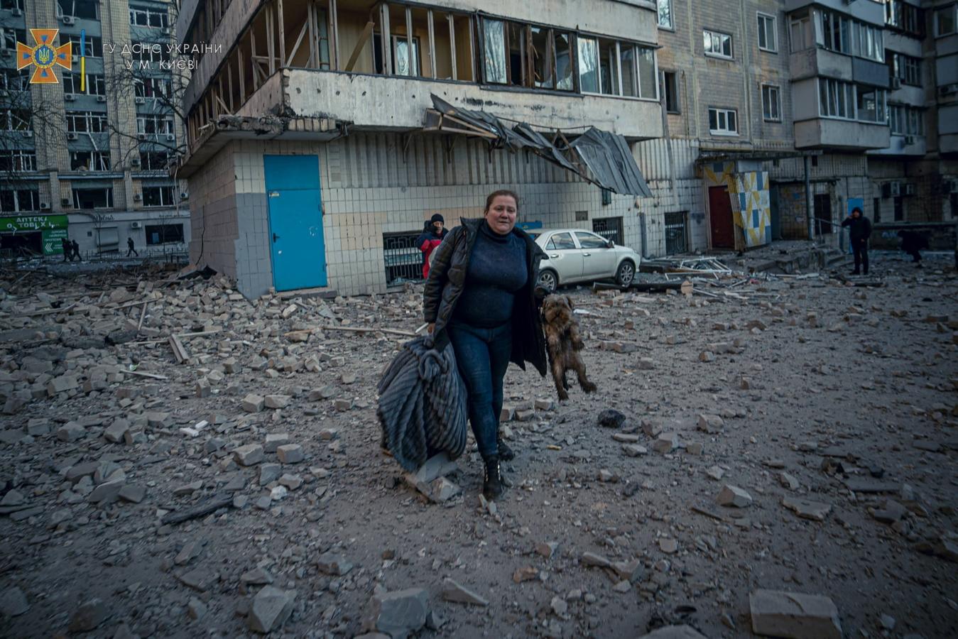 Una mujer y su perro son evacuados del edificio en el que residen tras ser atacado. 