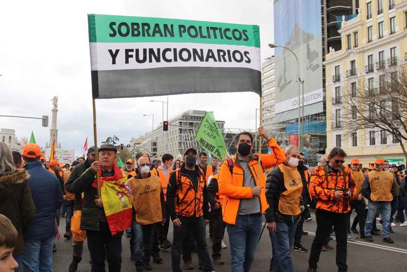 Un grupo de hombres participa en la manifestación con una bandera de Extremadura en la que puede leerse 'Sobran políticos y funcionarios'. 