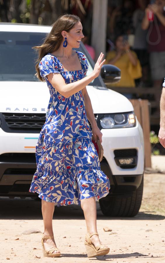 Los looks de Kate Middleton en su gira por el Caribe. En Belice lució un vestido azul fluido con estampado de flores y volantes de Tory Burch. Remató su elección con unas sandalias de tiras trenzadas y cuñas de Stuart Weizman y un clutch de rafia con una borla firmado por Anya Hindmarch