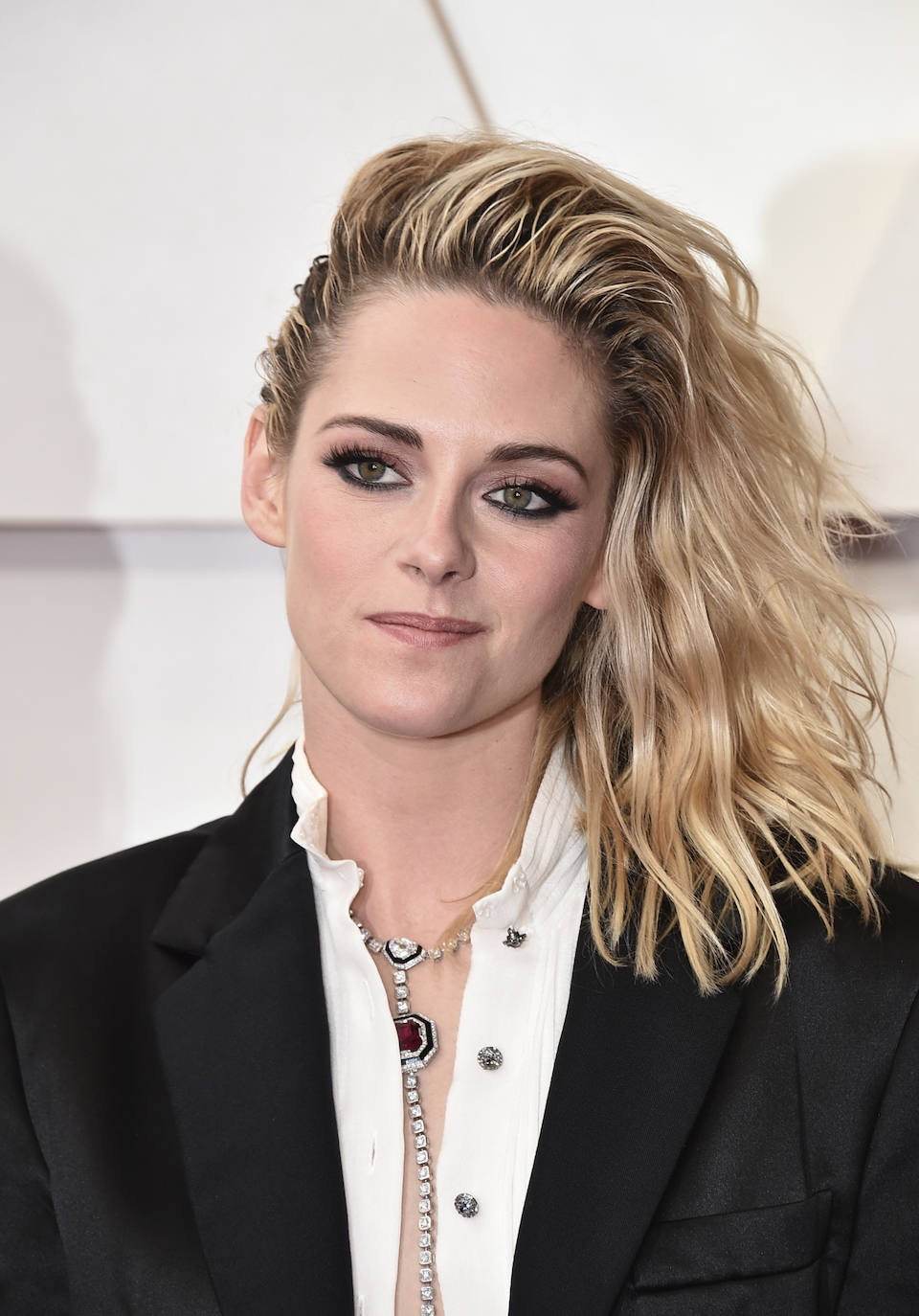 Kristen Stewart ha lucido una melena messy ladeada llena de volumen y movimiento creada por su estilista de cabecera Adir Abergel. Para ello ha utilizado dos productos que puedes encontrar en Sephora: Espuma Volumizadora Volumizing Mousse de Virtue y Create Volumizing Primer de Virtue para darle aspecto mojado. Un peinado que la actriz ha combinado con un favorecedor maquillaje  en el que ha destacado su mirada: sombras rosas, eyeliner negro completo y abundante máscara de pestañas.