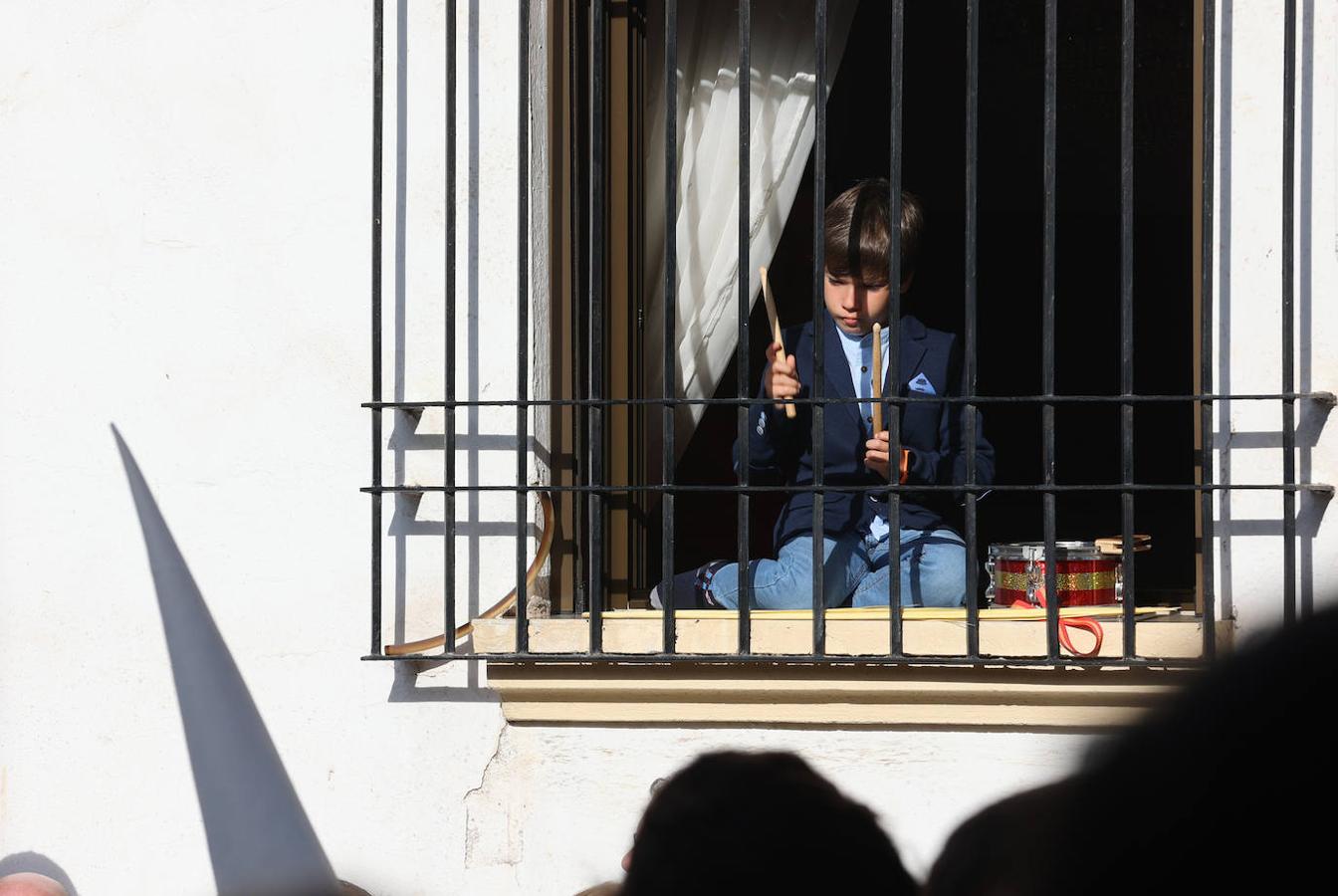 Un niño observa una procesión desde la ventana de su casa. 