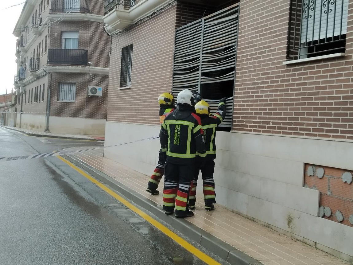 Tres bomberos cortan unas lamas metálicas para que puedan salir dos guardias civiles que entraron en este edificio abandonado
