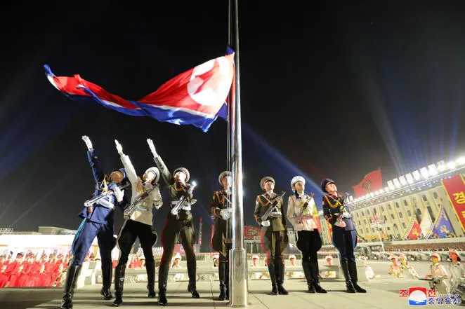 La bandera de Corea del Norte es izada durante el desfile. 
