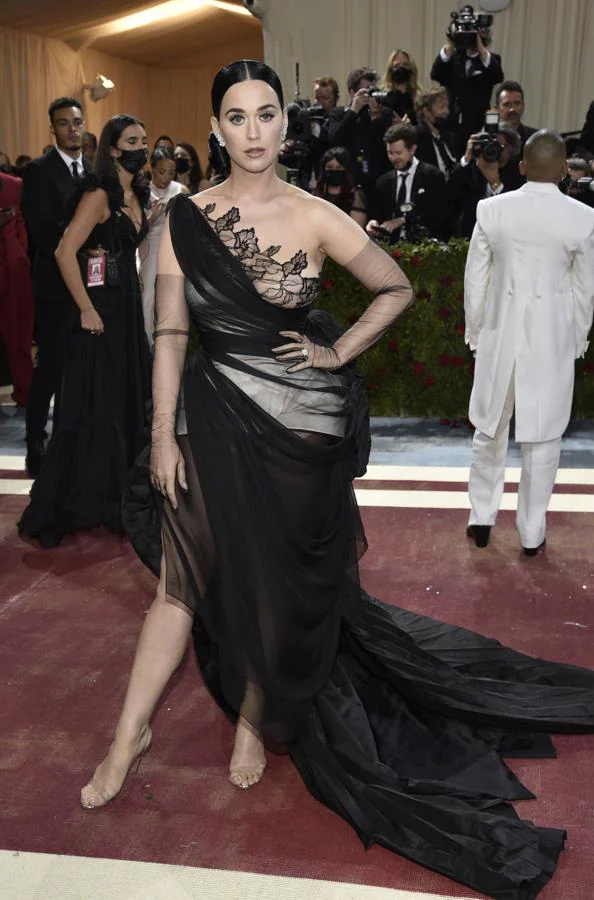 Katy Perry - Alfombra roja de la Gala MET 2022. Llevó un vestido negro con encaje, transparencias y una cola asimétrica con detalles de encaje.