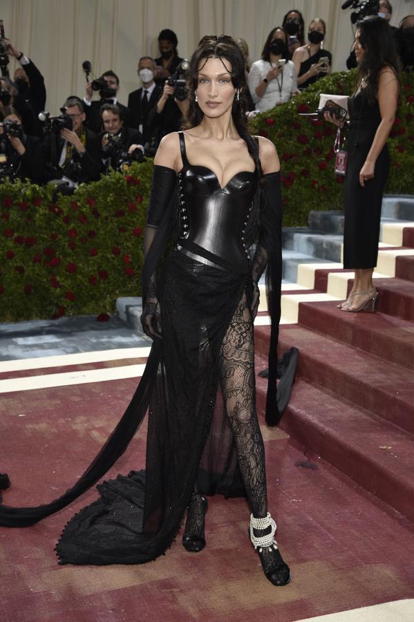 Bella Hadid - Alfombra roja de la Gala MET 2022. Llevó un vestido negro de burberry con un cuerpo encorsetado y medias de encaje.