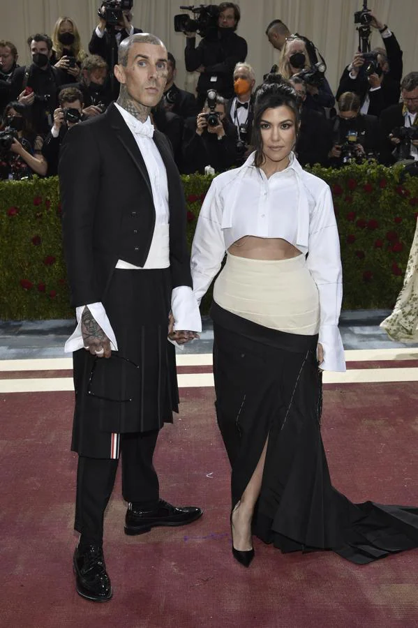 Kourtney Kardashian y Travis Barker - Alfombra roja de la Gala MET 2022. Llevó una falda bicolor con una larga cola que conjuntaba con la de su pareja, el miembro de Blink 182.