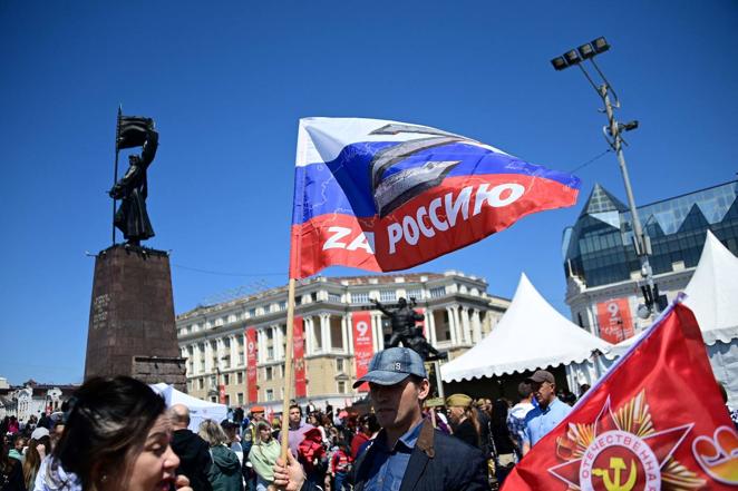 Un hombre sostiene una bandera rusa con una 'Z', símbolo de apoyo a la invasión de Ucrania. 