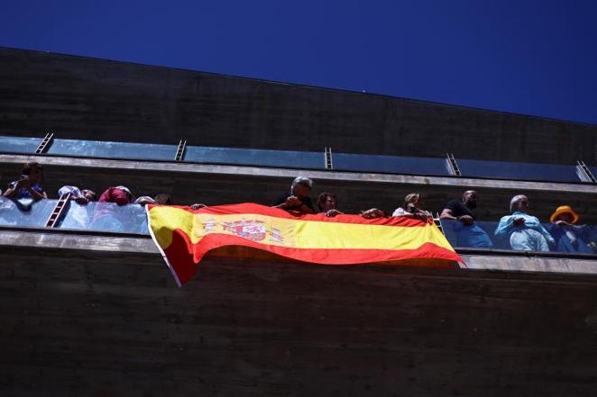 Varias personas portan una bandera de España en el puerto de Sangenjo