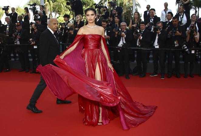 Sara Sampaio - Festival de Cannes 2022. Su look recuerda a los vestidos de las princesas con un diseño de Zuhair Murad en rojo pasión con el interior fucsia compuesto por una falda con vuelo, un cuerpo drapeado y aberturas en la falda.