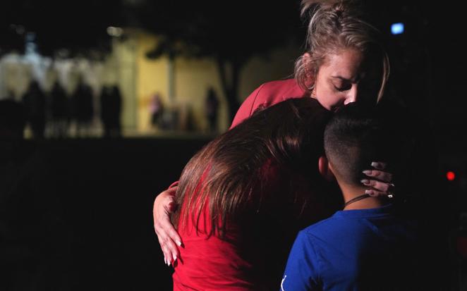 Las familias se abrazan fuera del Centro Cívico Willie de Leon donde se celebra un acto de duelo, en Uvalde. 