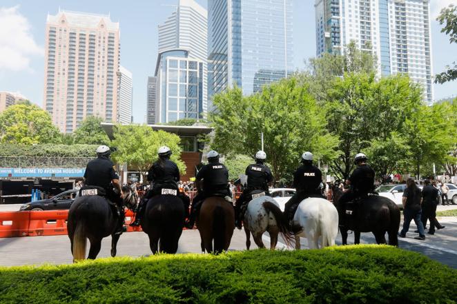 Varios policías a caballo vigilan la entrada de la Convención Nacional del Rifle que se celebra en Houston (Texas), pues varios manifestantes se han reunido a sus puertas para protestar contra la facilidad para obtener armas en Estados Unidos.