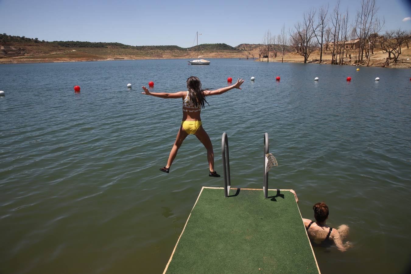 En imágenes, el primer baño veraniego en la playa del embalse de la Breña