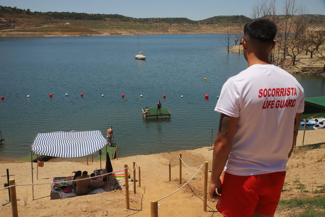 En imágenes, el primer baño veraniego en la playa del embalse de la Breña