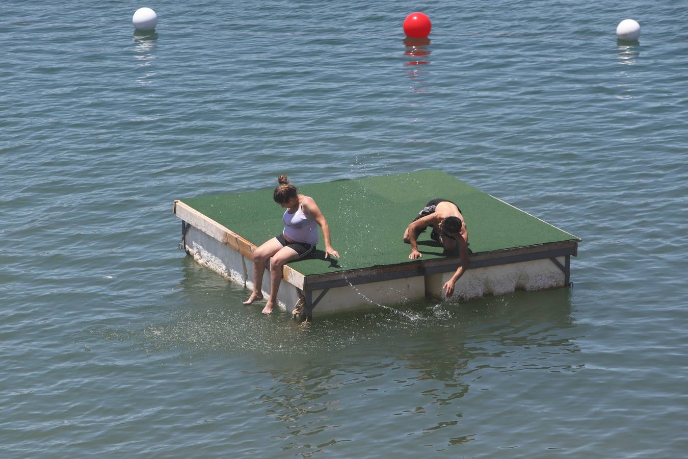 En imágenes, el primer baño veraniego en la playa del embalse de la Breña