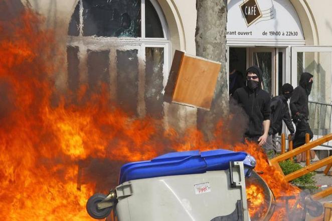 4 de abril de 2009. Manifestantes contra la OTAN arrojan los muebles de un hotel al fuego, antes de prender fuego al edificio cerca del puente Europa, al este de Estrasburgo, durante la cumbre del 60 aniversario de la OTAN. La policía disparó gases lacrimógenos y bombas de destello contra los manifestantes que lanzaban cócteles Molotov y piedras a menos de 3 kilómetros de la reunión de líderes mundiales para la cumbre del 60 aniversario de la OTAN.. 