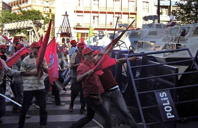 26 de junio de 2004. Unos manifestantes turcos de izquierdas utilizaron palos para intentar derribar una barricada policial durante una protesta en Ankara, antes de la llegada al país del presidente Bush.. 