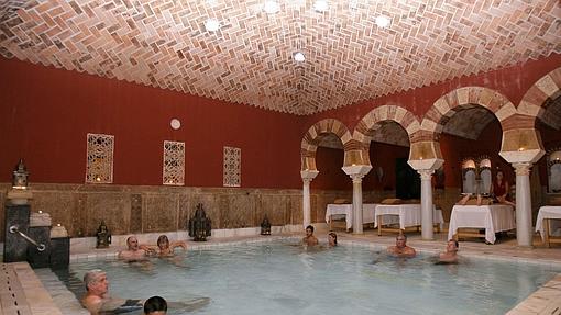 Un grupo de personas disfrutando de la piscina templada en los Baños Árabes