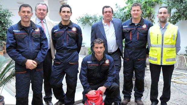 Antonio Navarrete, sin uniforme ni corbata, junto a bomberos