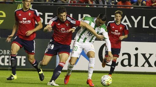 Raúl de Tomás resiste la entrada de un jugador de Osasuna