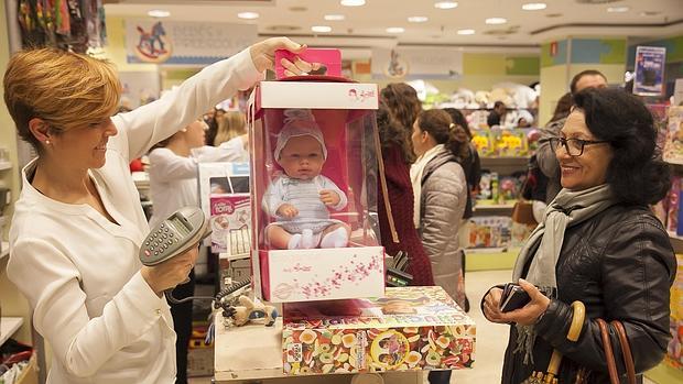 Una mujer compra una muñeca en El Corte Inglés