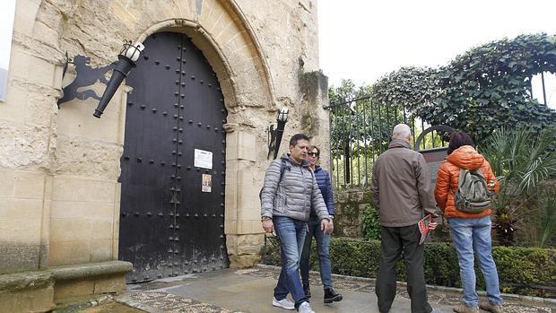 Unos turistas ante la puerta cerrada del Alcázar