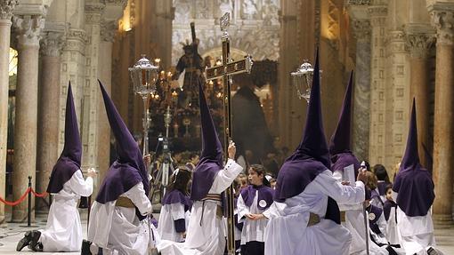 Nazarenos de la Santa Faz arrodillados, con el paso al fondo