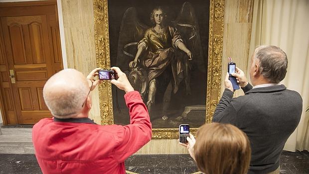 Ciudadanos fotografían el cuadro de San Rafael, de Antonio del Castillo, tras su restauración