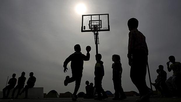 Un grupo de niños refugiados juega en el puerto del Pireo griego