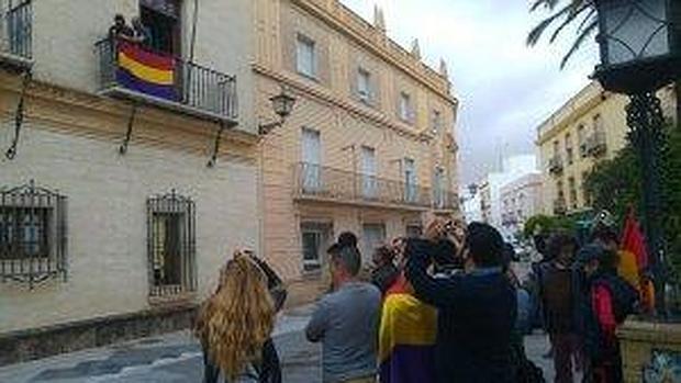 Dos concejales cuelgan la bandera en el balcón del Ayuntamiento