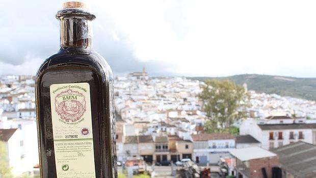 Botella de aceite de la Denominación de Origen Baena, con el muncipio baenense al fondo