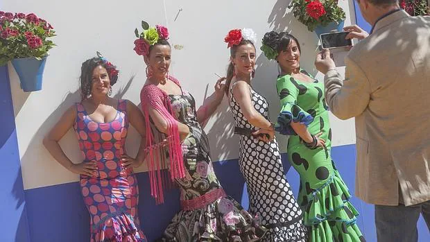 Cuatro mujeres posan para una fotografía ante una caseta de la Feria de Córdoba