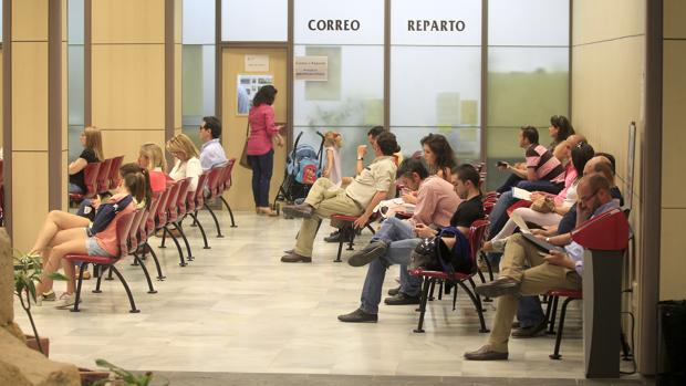 Varios ciudadanos esperan su turno en la oficina de atención al público de Capitulares