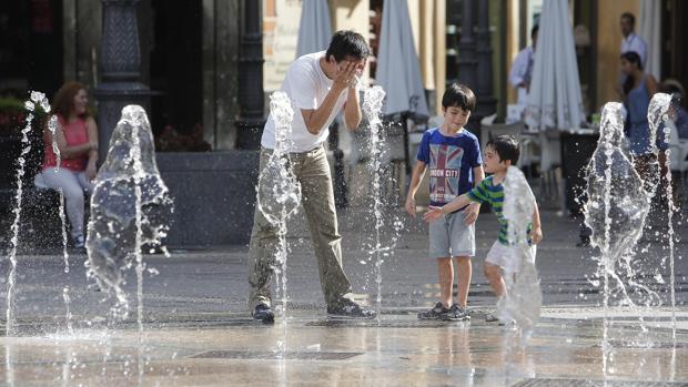 Una familia se refresca en los chorros de Las Tendillas