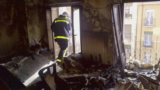 Un bombero en el interior de una vivienda totalmente calcinada por el fuego