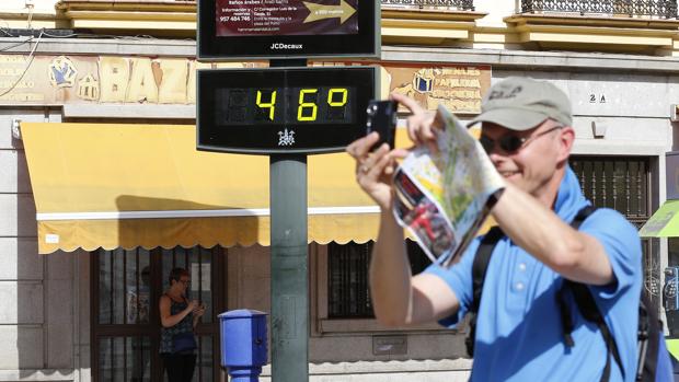 Un turista fotografía un termómetro público en Córdoba