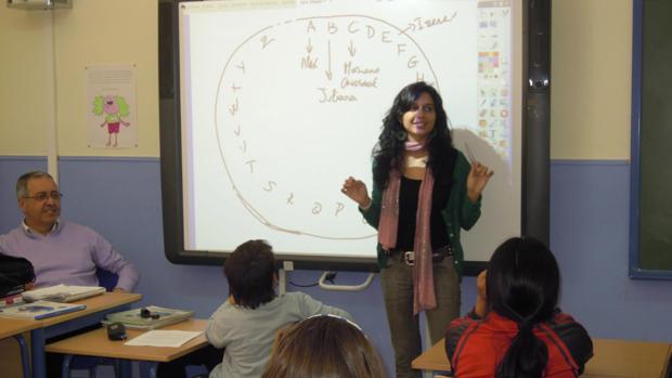 Una profesora imparte clases con una pizarra electrónica