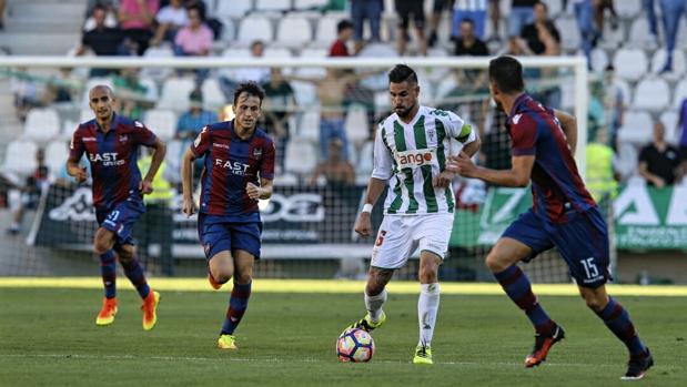 El capitán del Córdoba CF, Luso, conduce el balón ante varios rivales del Levante