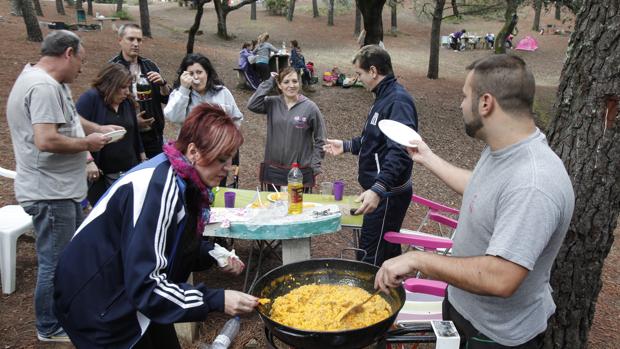 Una familia degusta un perol de arroz en el parque de Los Villares