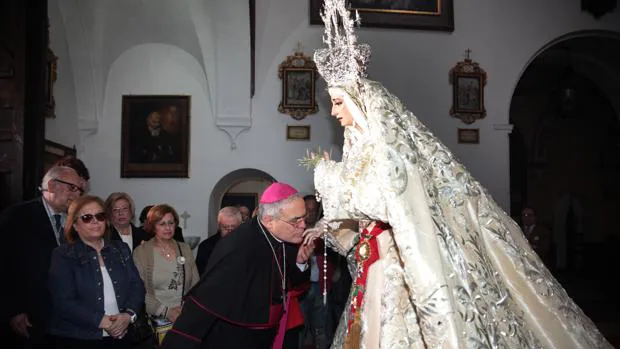 El obispo de Córdoba besa la mano de la Virgen de la Paz