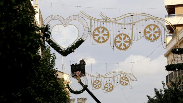 Un operario ultima los detalles en las luces de Navidad