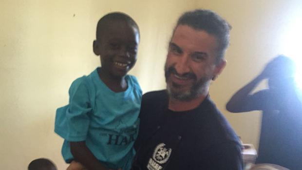 Antonio García sostiene en brazos a un niño en Haití
